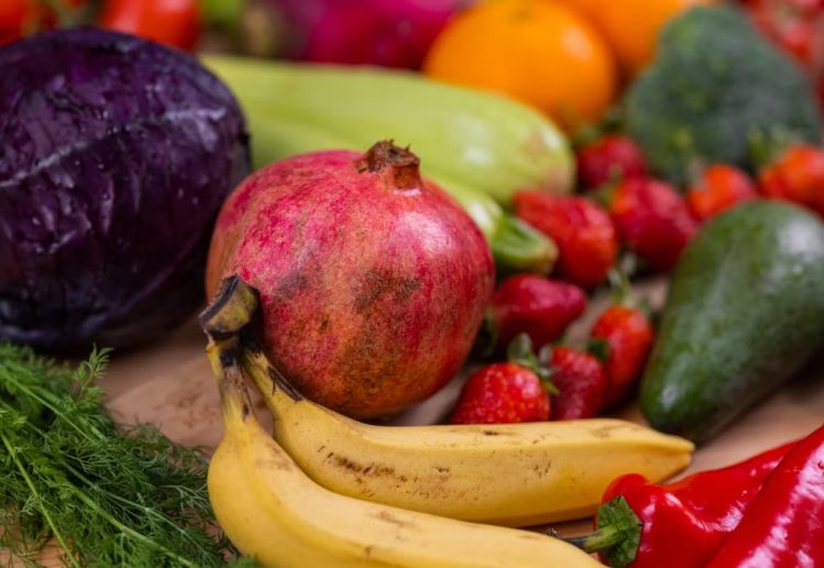 A variety of fresh fruits and vegetables arranged beautifully on a wooden table, showcasing natural nutrition.