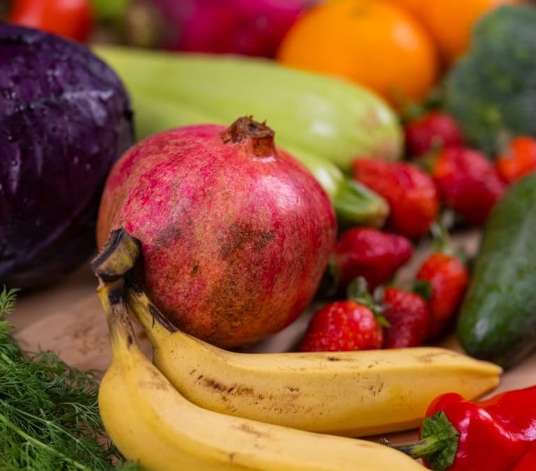 A variety of fresh fruits and vegetables arranged beautifully on a wooden table, showcasing natural nutrition.